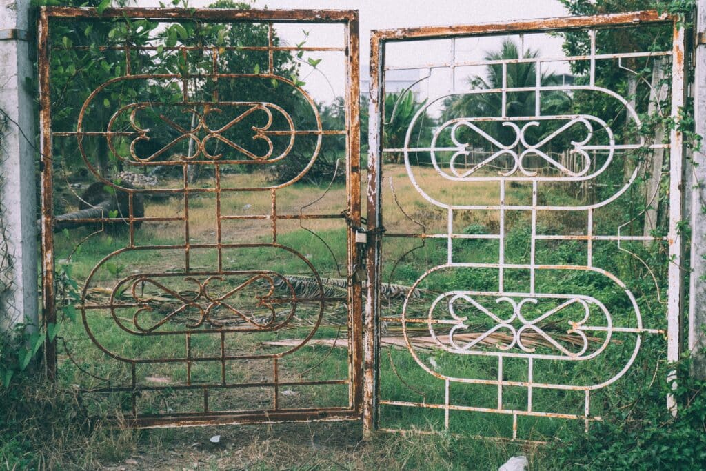 a broken metal gate that needs to be replace